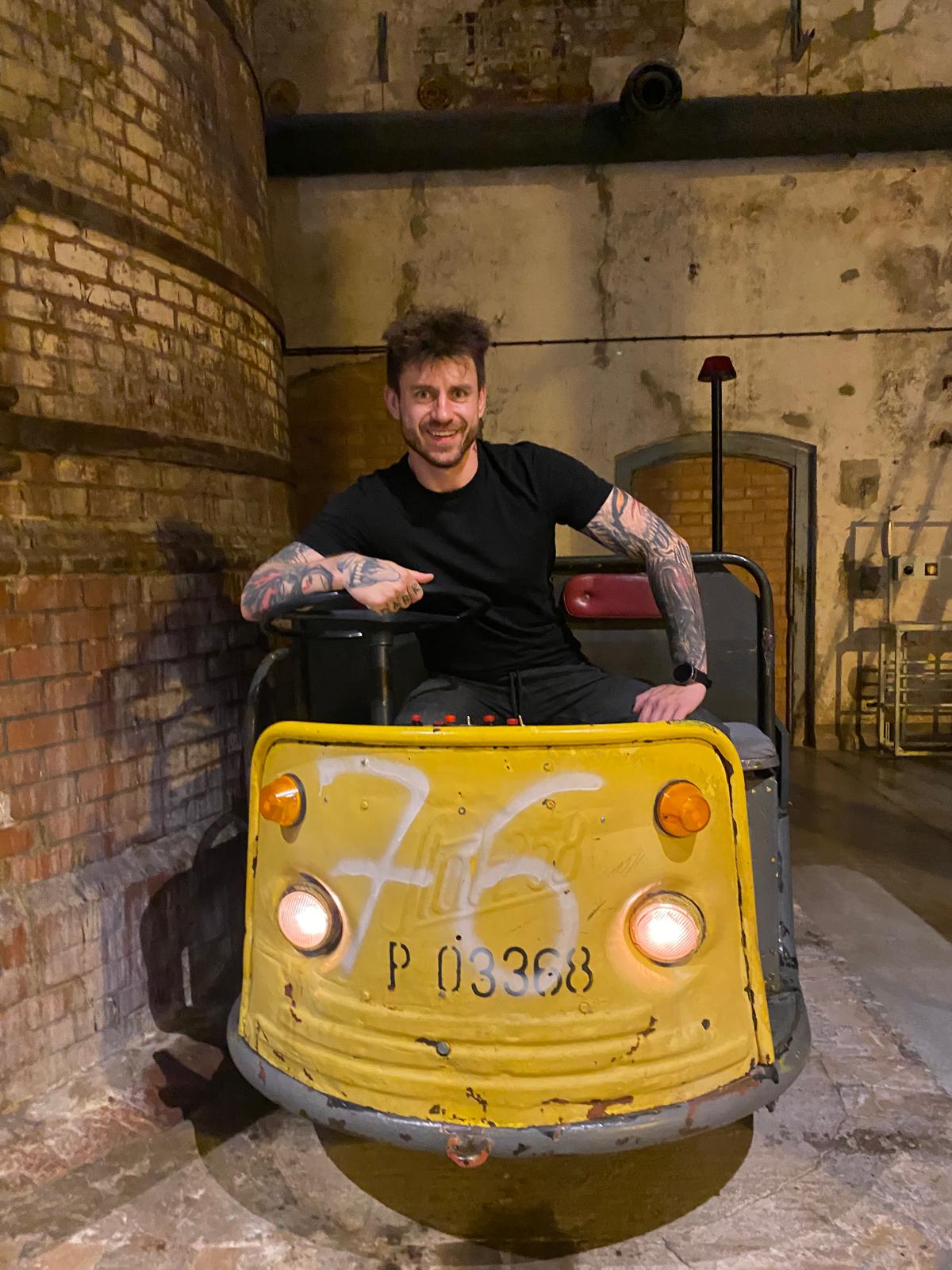 Adam Miszczak, international e-commerce SEO specialist, sitting on a small yellow mining train underground.