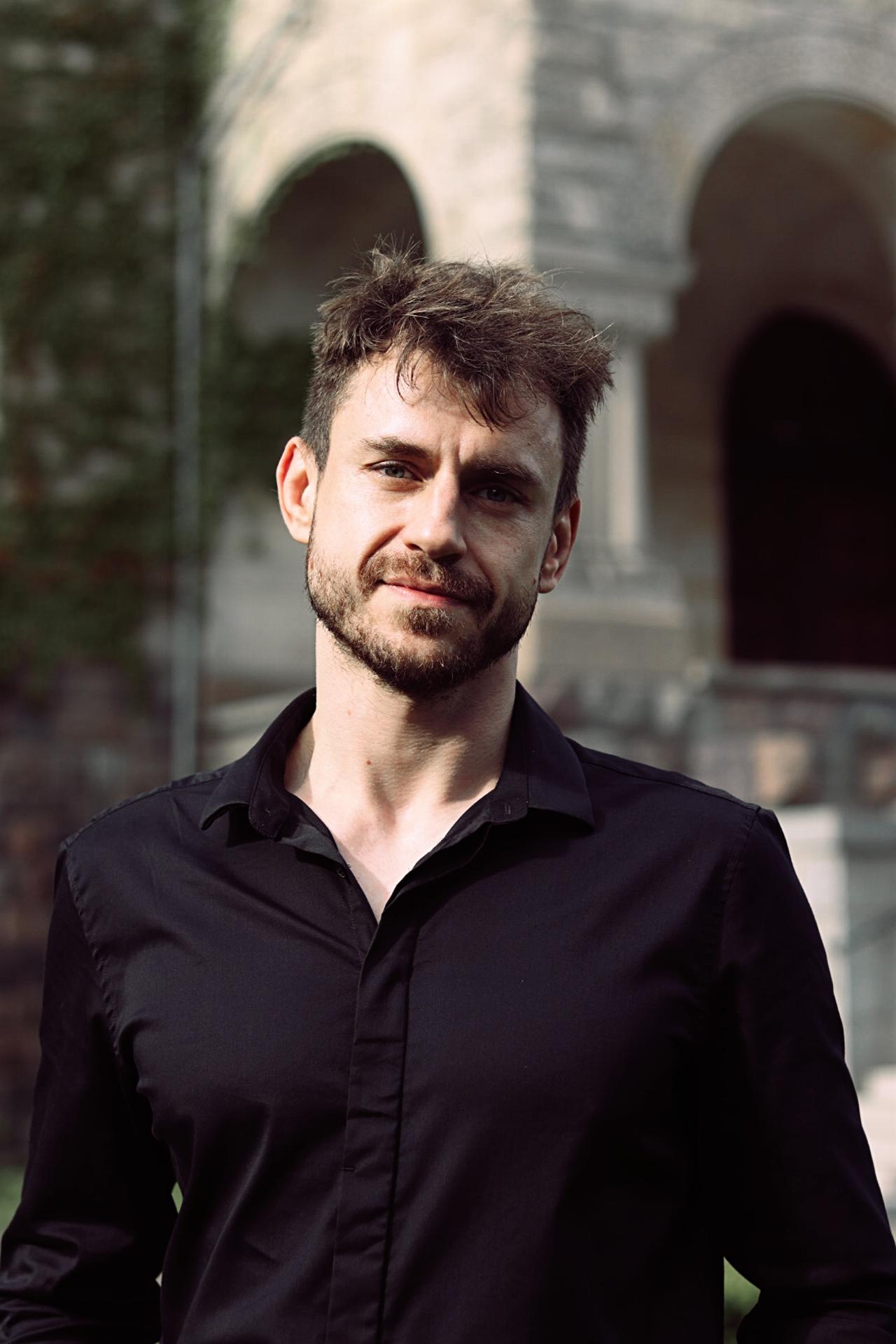 Adam Miszczak, enterprise SEO and GEO specialist, in a black shirt outdoors.